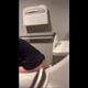 A hidden camera records an unsuspecting girl from behind as she sits on a toilet in a public restroom and takes a shit. You can see her seated rear view throughout, and bathroom audio is audible. Vertical format video. About 2.5 minutes.